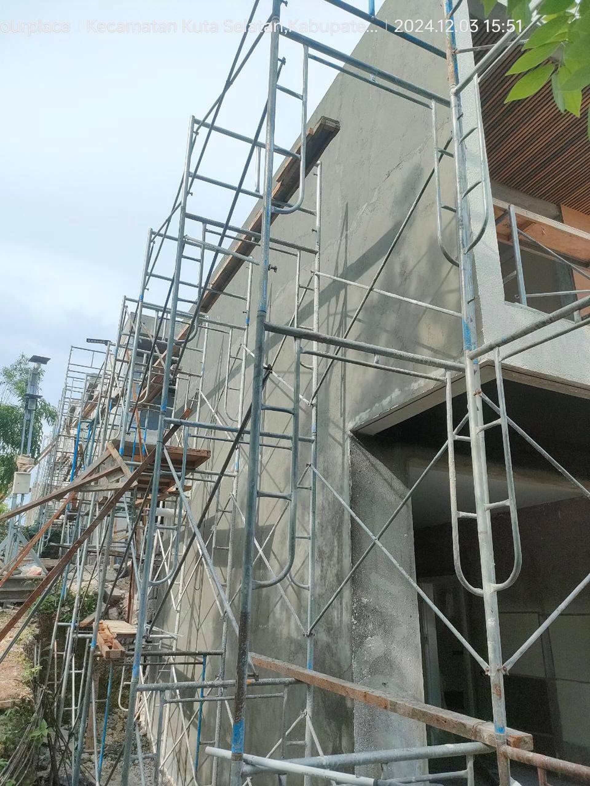 Construction progress — villa concrete exterior walls with scaffolding — Frigate Bali