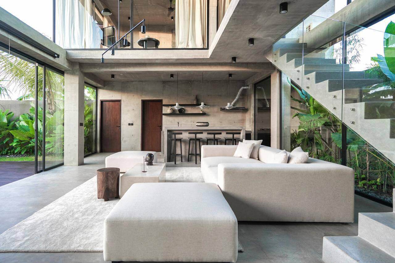 Open-plan villa living room with concrete staircase and garden access — Frigate Bali