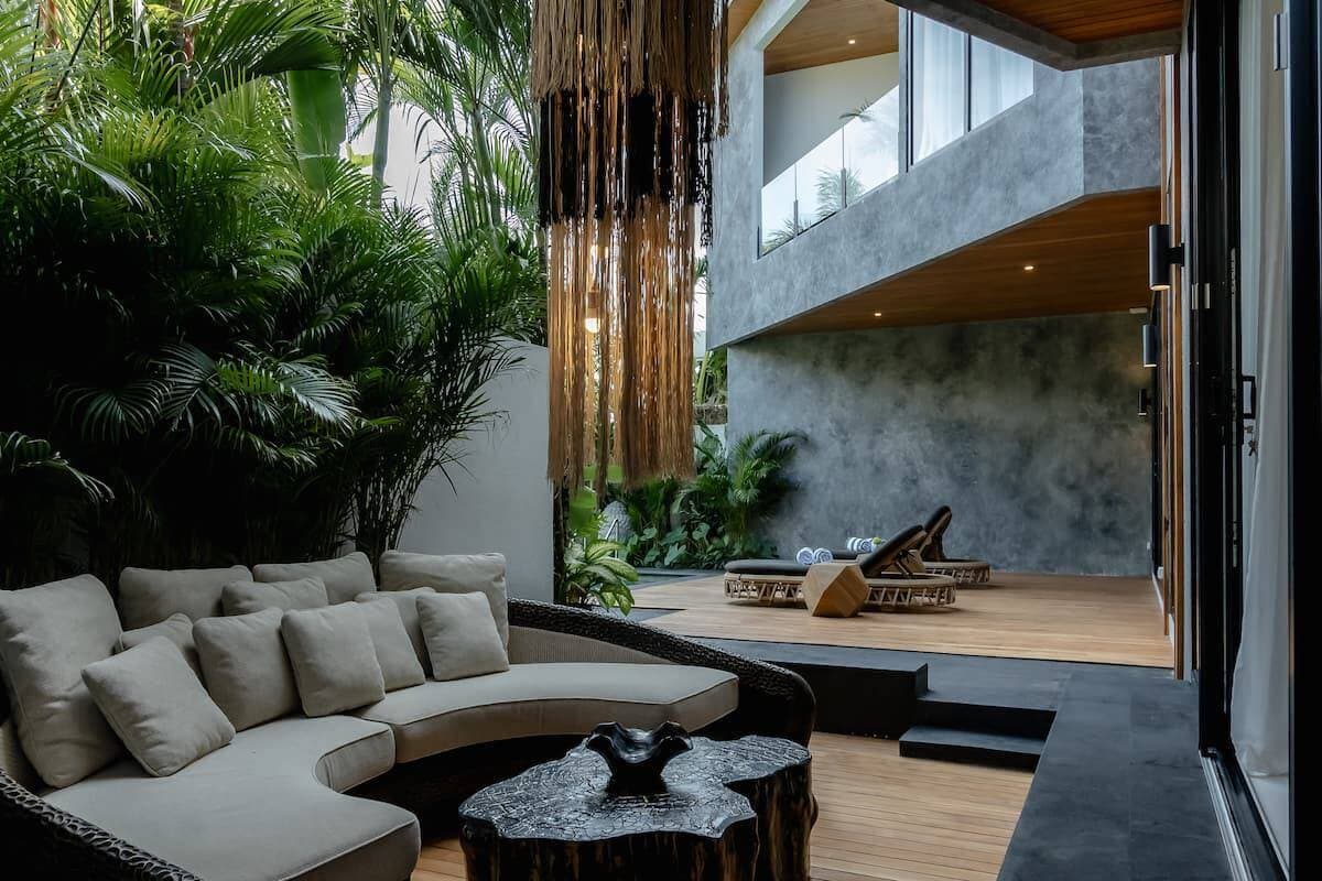 Modern villa outdoor terrace with rattan lounge and tropical garden — Frigate Bali